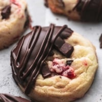 close up view of almond cherry cookie with chocolate chunks, dipped in chocolate