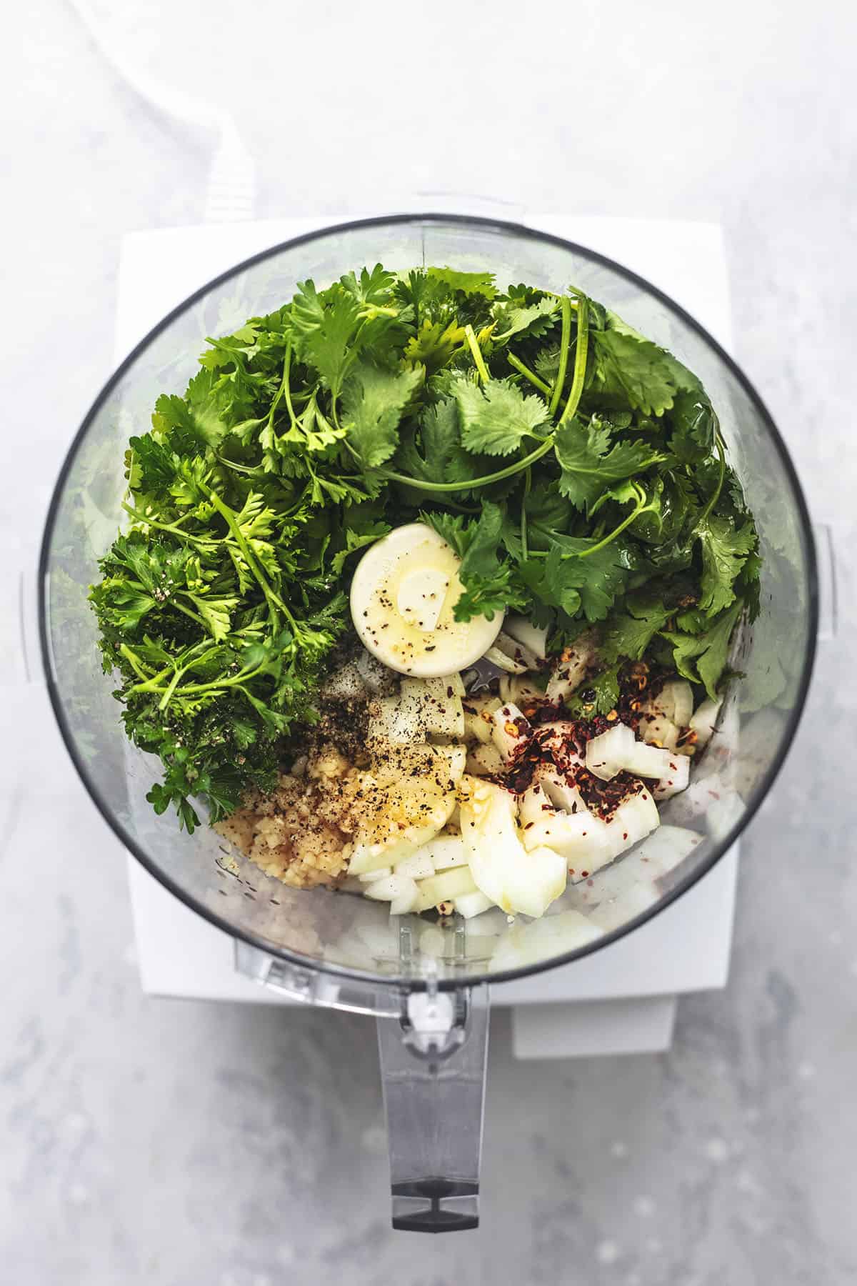 overhead view of ingredients for chimichurri sauce inside of food processor