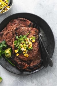 overhead view of cooked steak on plate topped with corn salsa