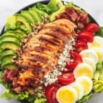 overhead view of chicken cobb salad with avocado and bacon in a bowl