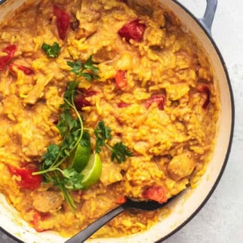 overhead view of curry chicken and rice with bell peppers in skillet