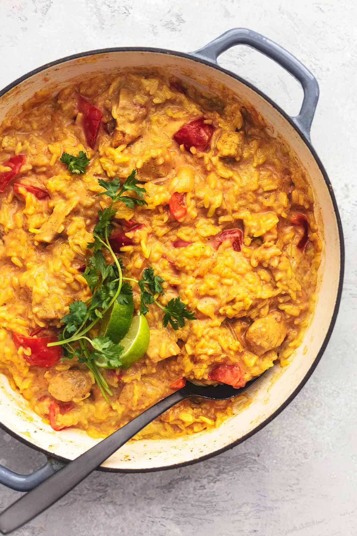 overhead view of curry chicken and rice with bell peppers in skillet