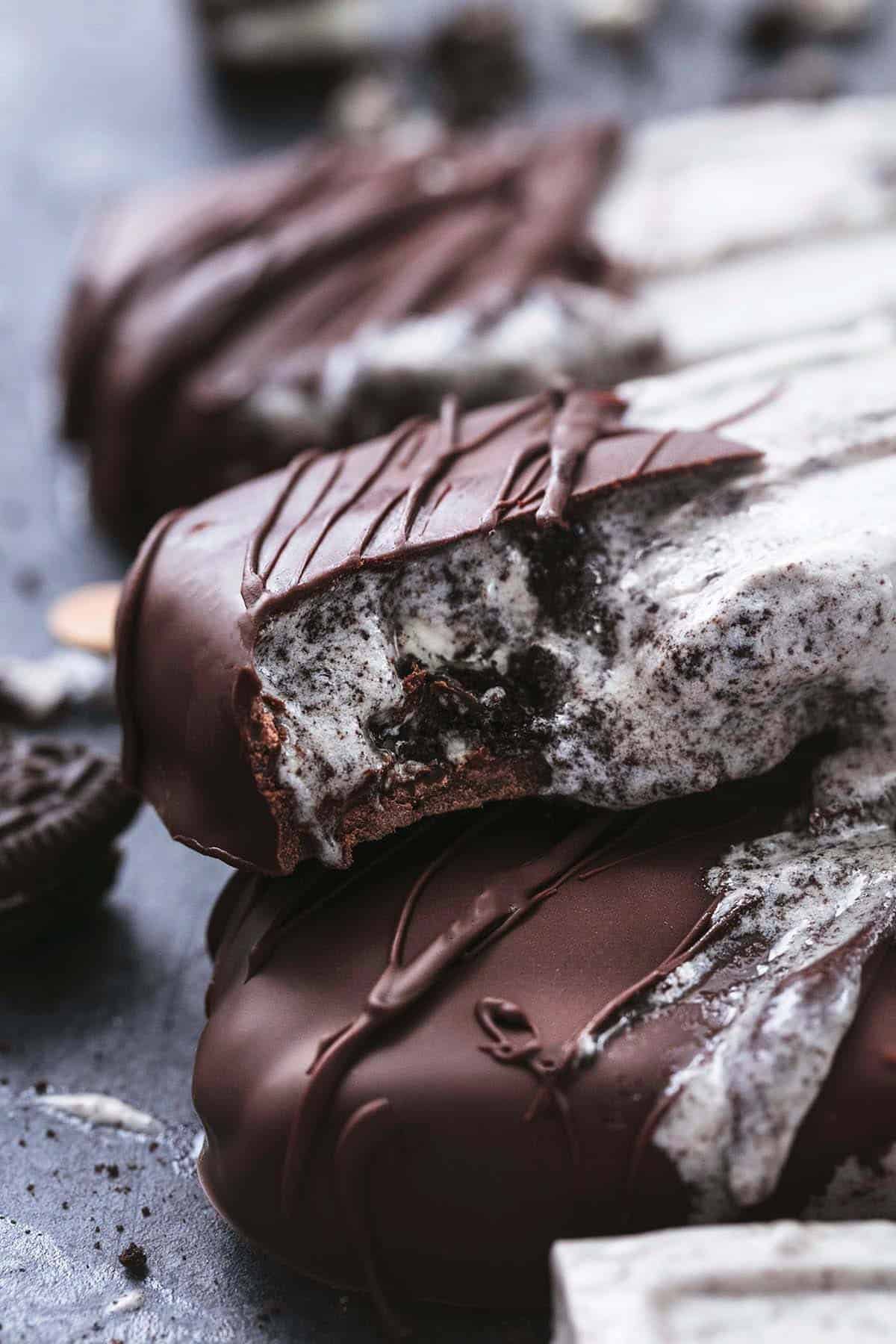 chocolate covered oreo popsicle with bite out of it stacked on second popsicl