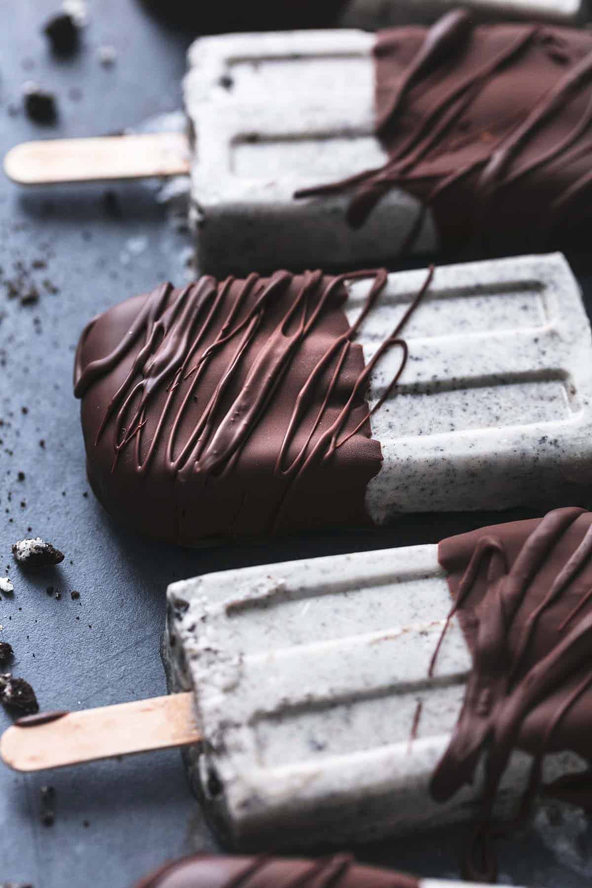 chocolate covered oreo popsicles laying on a black surface