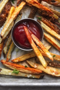 up close overhead french fries on sheet pan with ketchup in cup