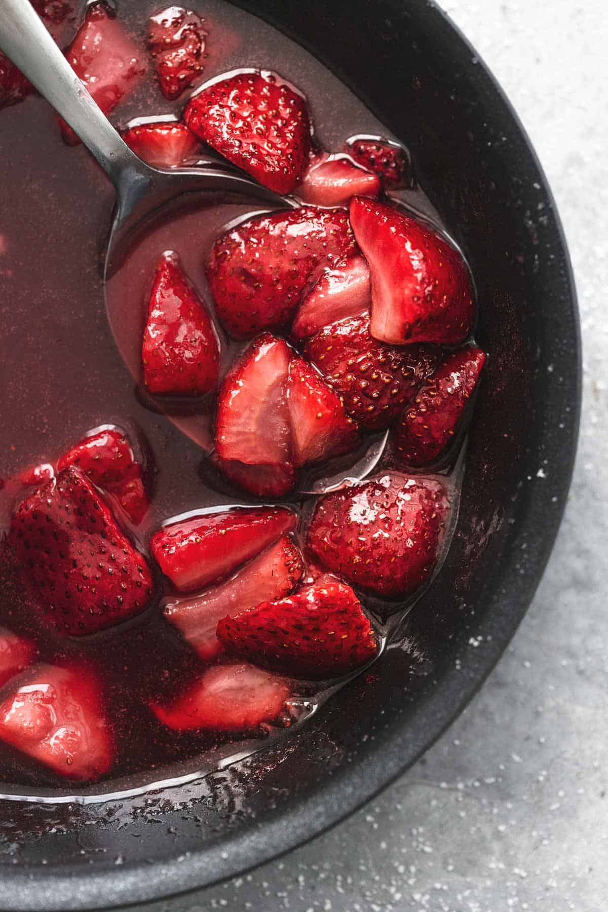 close up top view of strawberries and strawberry sauce in a skillet.