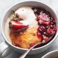 up close view of strawberry cobbler with ice cream in a bowl with a spoon