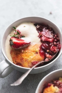 up close view of strawberry cobbler with ice cream in a bowl with a spoon