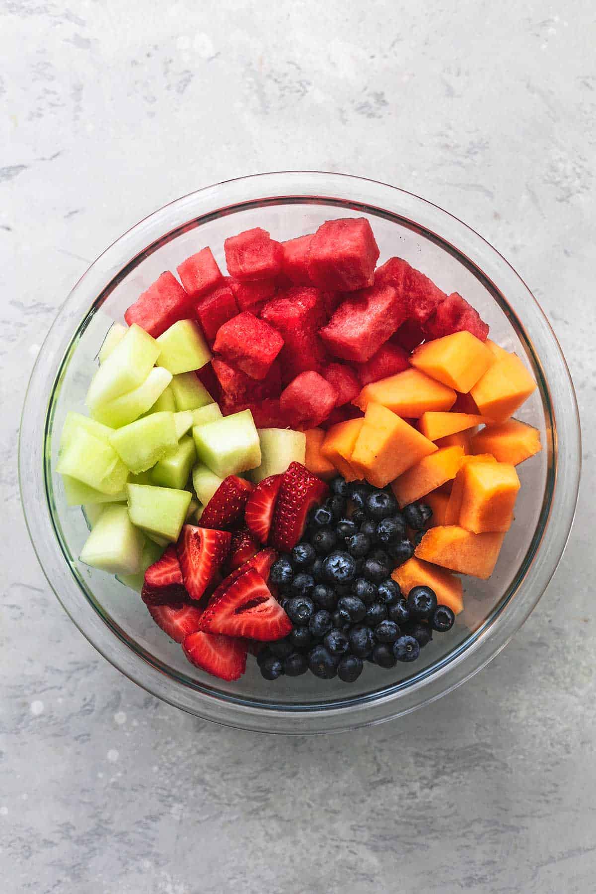 top view of summer melon fruit salad in a glass bowl not yet mixed together.