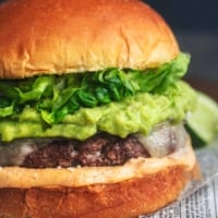 up close detail photo of turkey burger with cheese, mayo, guacamole, and lettuce