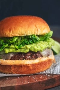 up close detail photo of turkey burger with cheese, mayo, guacamole, and lettuce