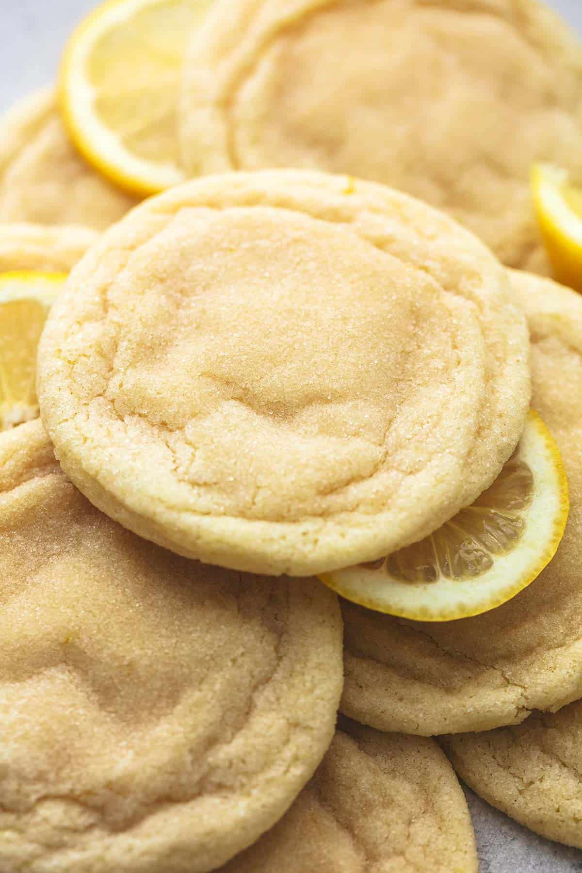 close up of snow capped lemon cookies not yet dipped in white chocolate with lemon wheels.