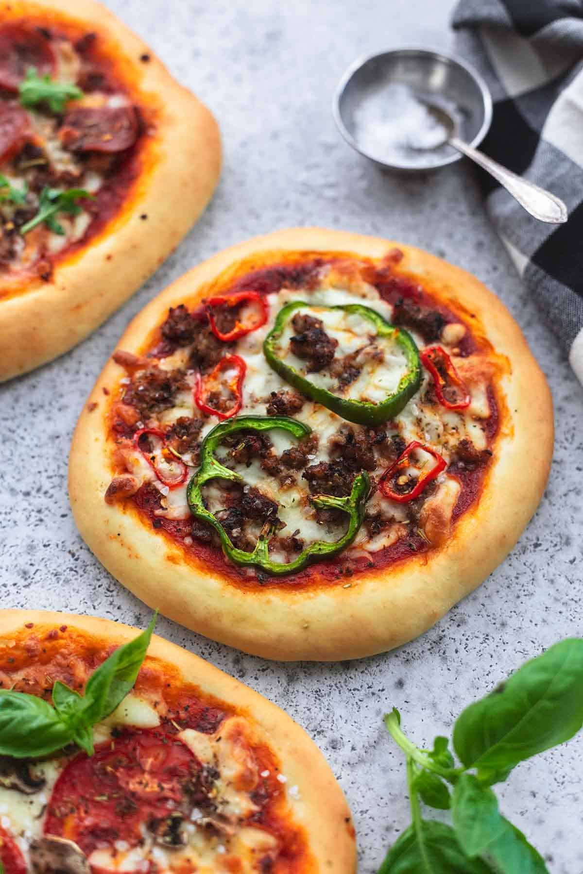 personal pizza with green bell pepper slices and ground sausage