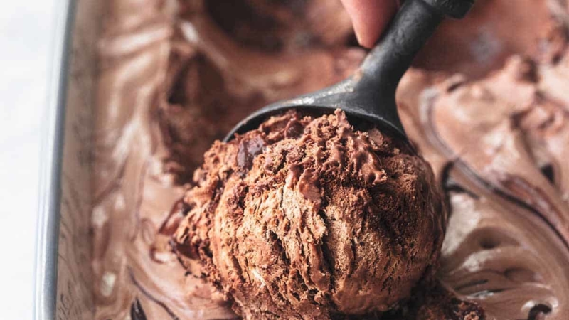 hand scooping chocolate ice cream