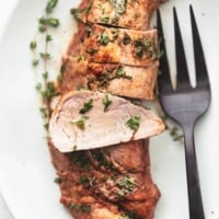 overhead sliced pork tenderloin on platter with serving fork