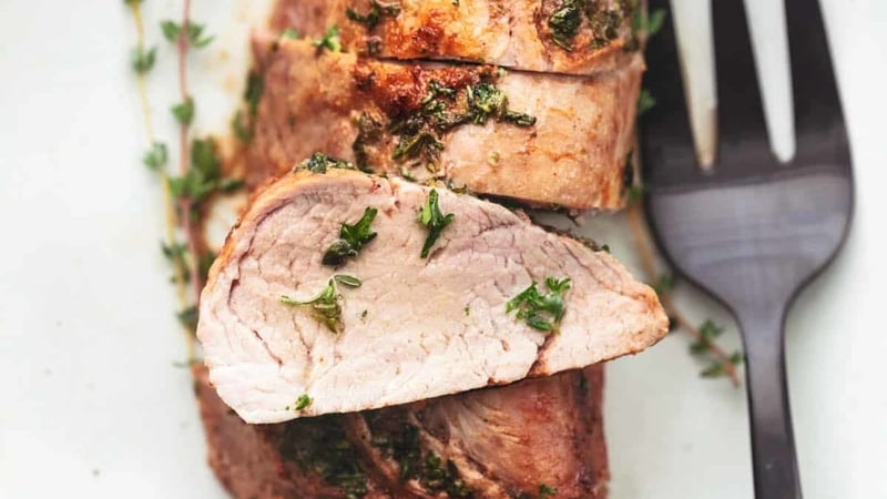 overhead sliced pork tenderloin on platter with serving fork