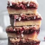 head-on view of stack of raspberry crumb bars with vanilla glaze