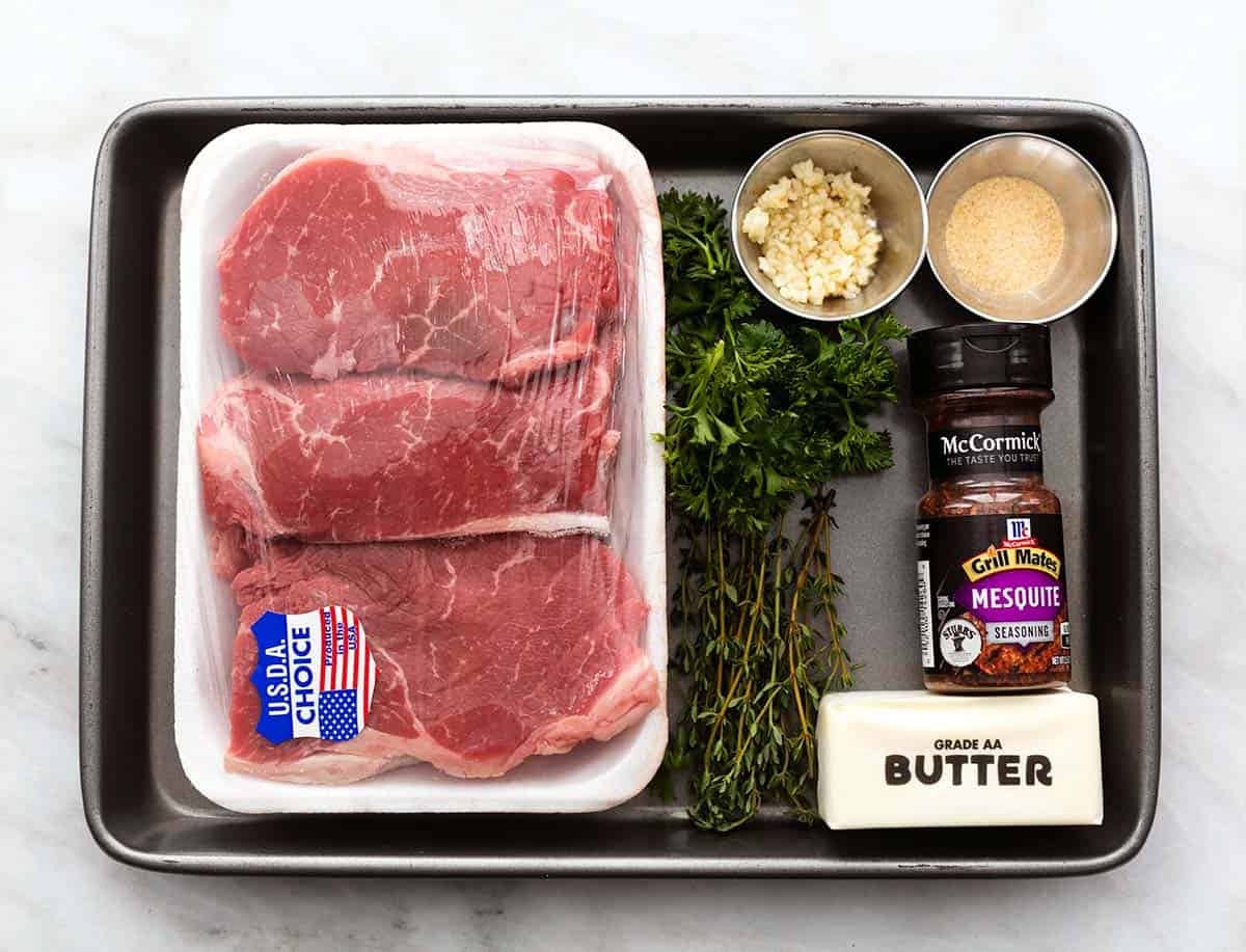top view of ingredients for grilled sirloin steak on a baking sheet.