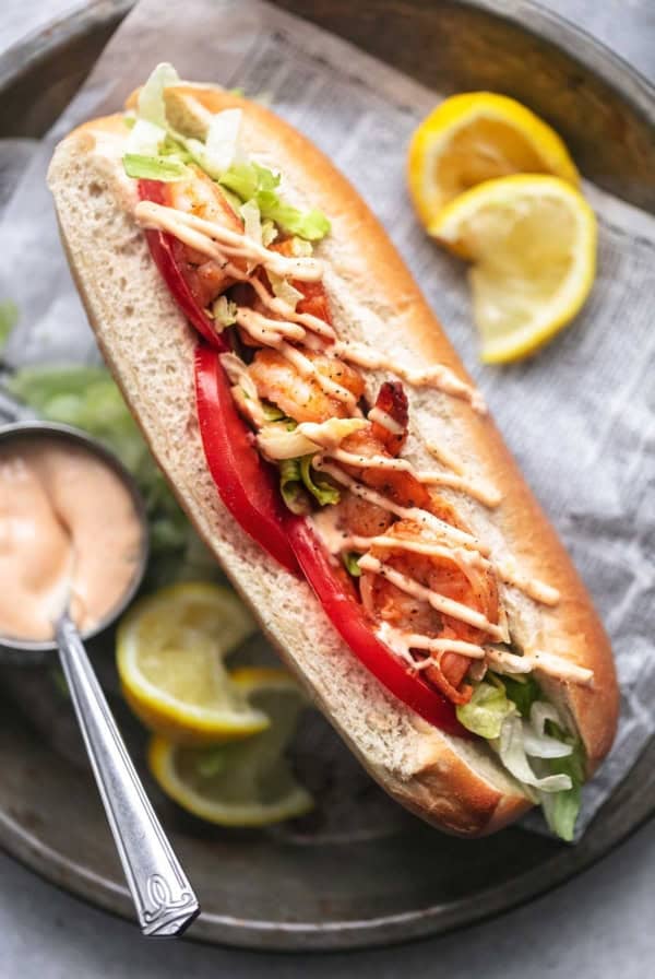 overhead close up view of split bun sandwich with tomatoes lettuce and shrimp