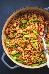 chicken chow mein in a skillet with a serving spoon