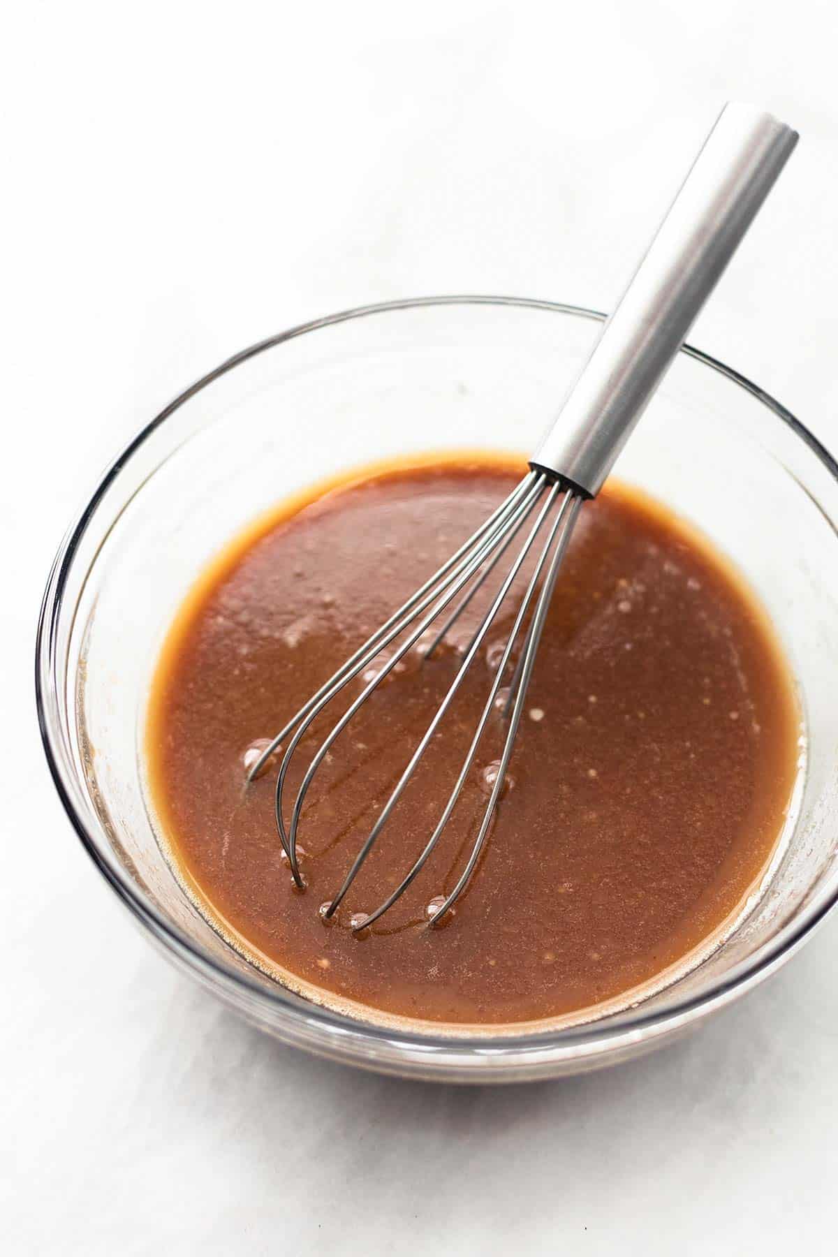 brown sauce and a whisk in a glass bowl.