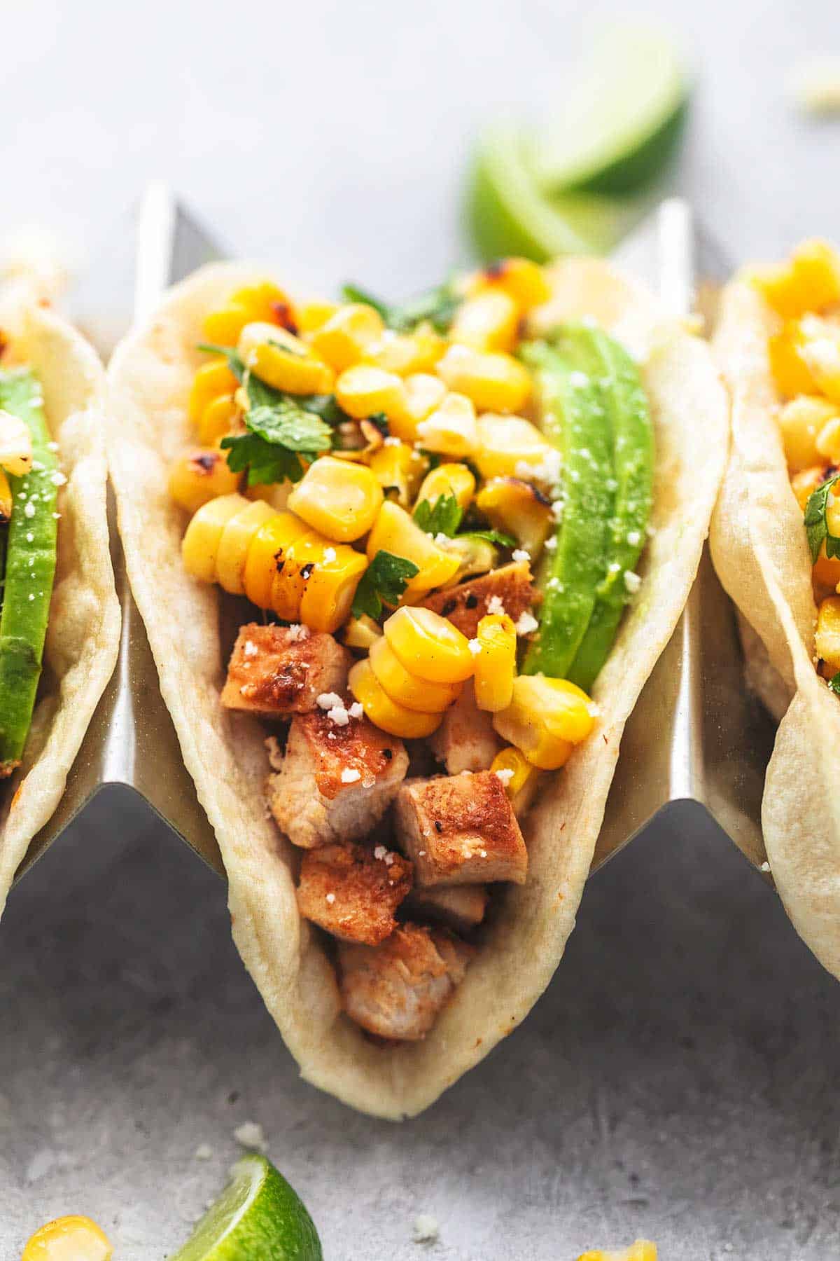 close up of a chicken taco in a taco holder topped with corn salsa.