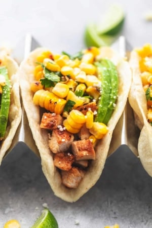 up close single chicken taco in taco holder topped with corn salsa