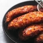 browned chicken with breading on a black plate