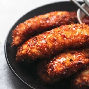 browned chicken with breading on a black plate