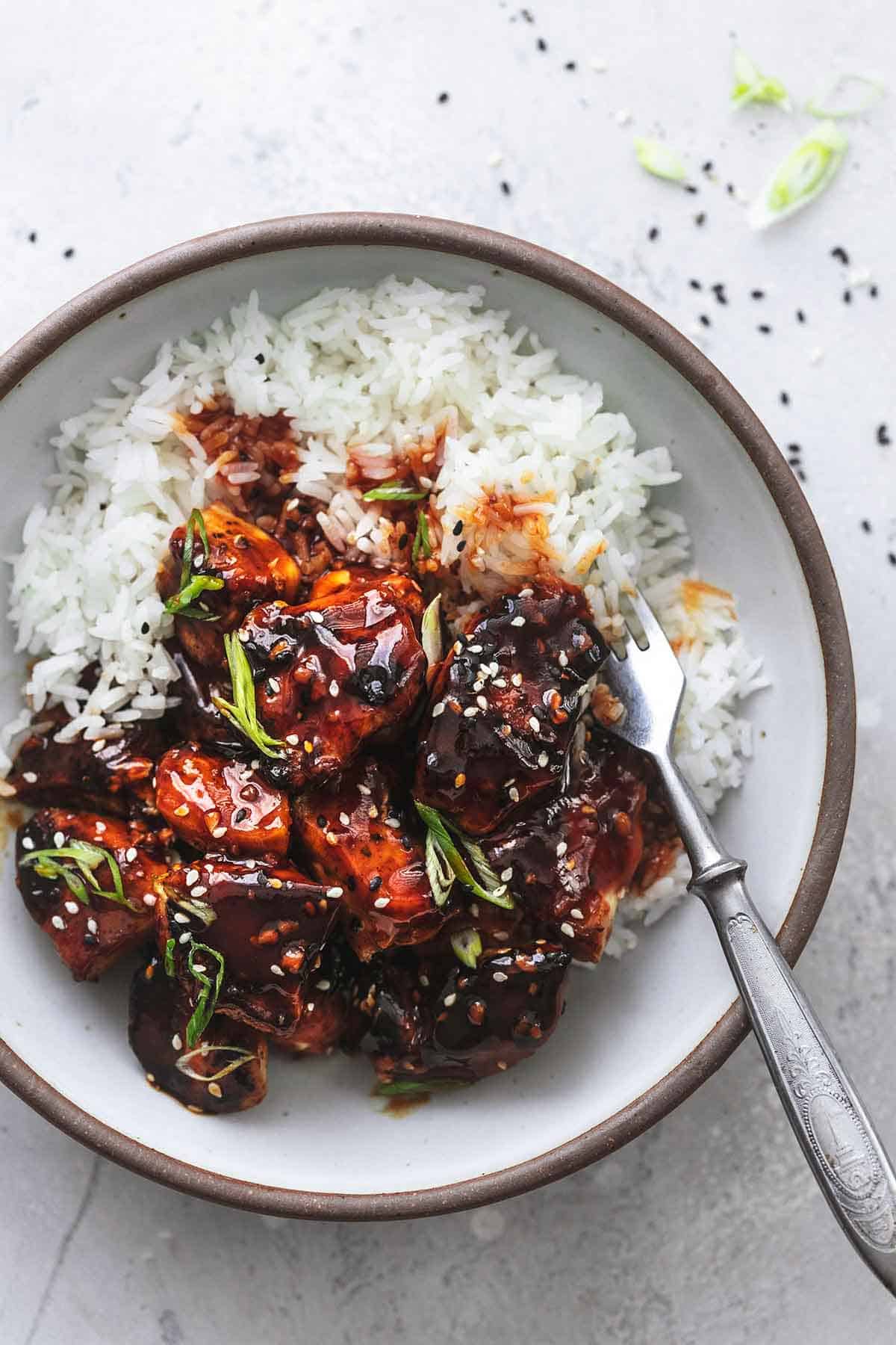 overhead Asian chicken in dark red sauce over white rice in bowl