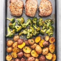 overhead view of sheet pan meal with pork chops, broccoli, and potatoes