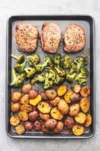 overhead view of sheet pan meal with pork chops, broccoli, and potatoes
