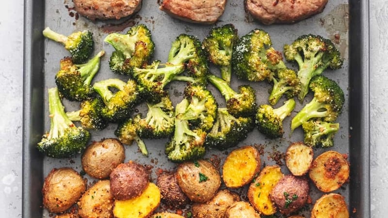 overhead view of sheet pan meal with pork chops, broccoli, and potatoes