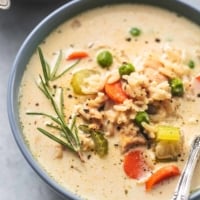 up close view of 3/4 of a bowl of soup with chicken, vegetables, and rice with rosemary