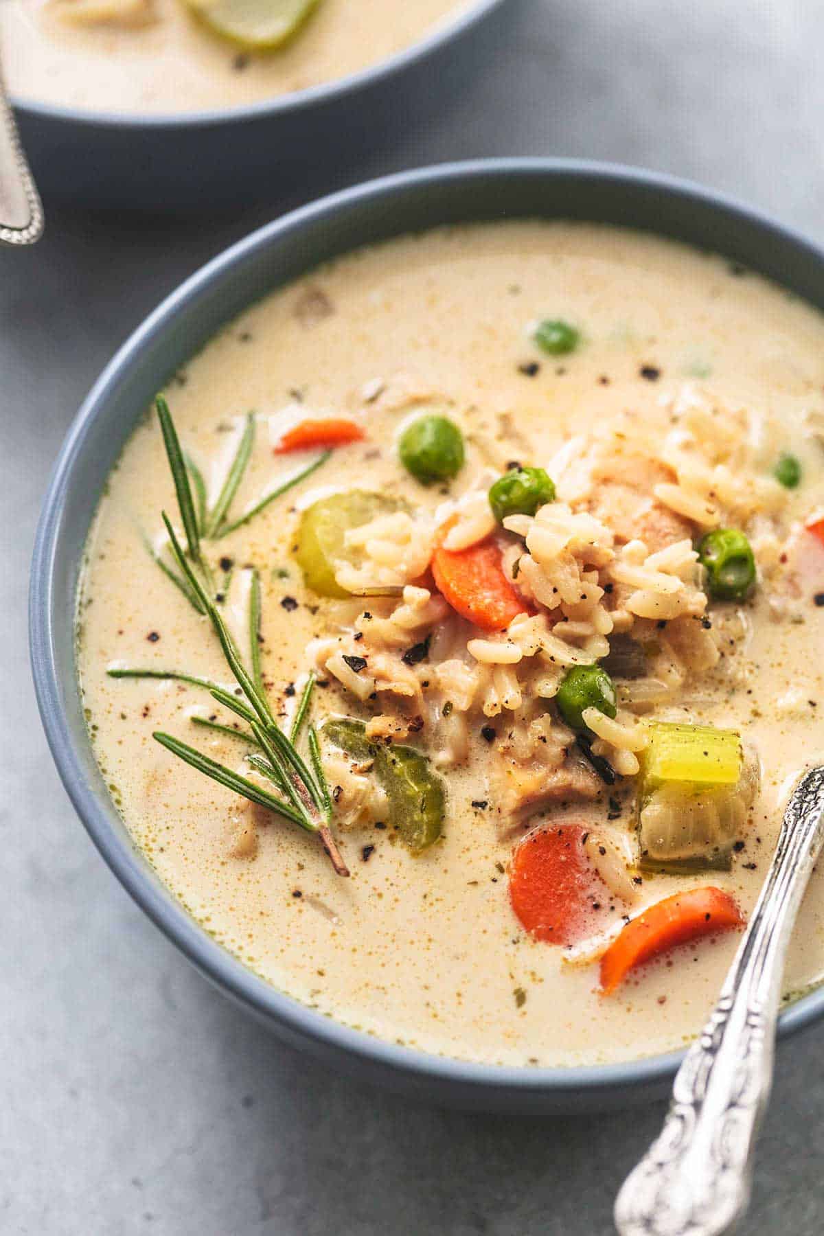 up close view of 3/4 of a bowl of soup with chicken, vegetables, and rice with rosemary