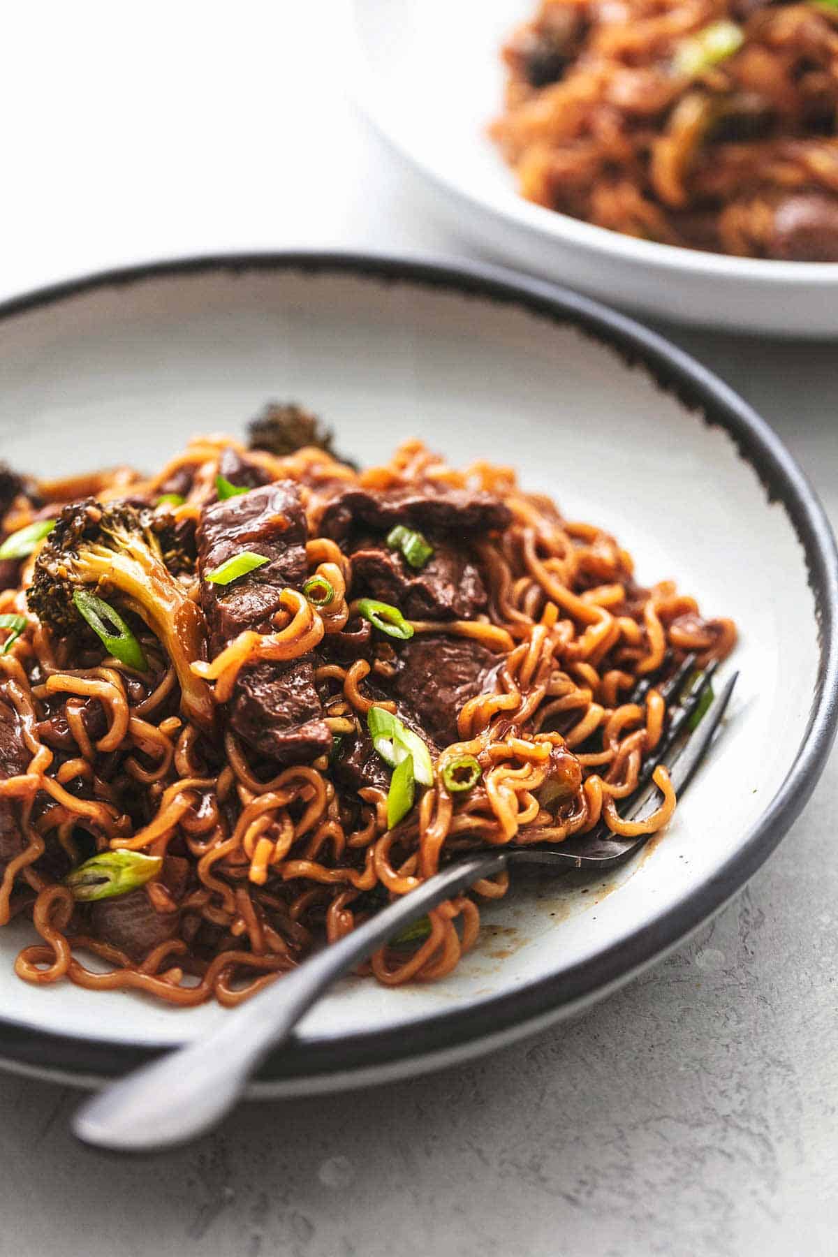 close up of Magnolian beef and broccoli with noodles with a fork on a plate.