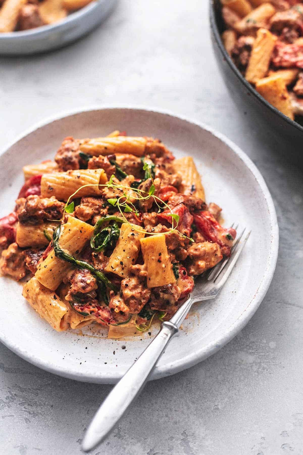 tuscan sausage pasta with a fork on a plate.