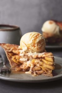 single slice of pie with apple cinnamon filling and ice cream on top