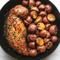 overhead view of pork tenderloin and baby potatoes cooked in a skillet