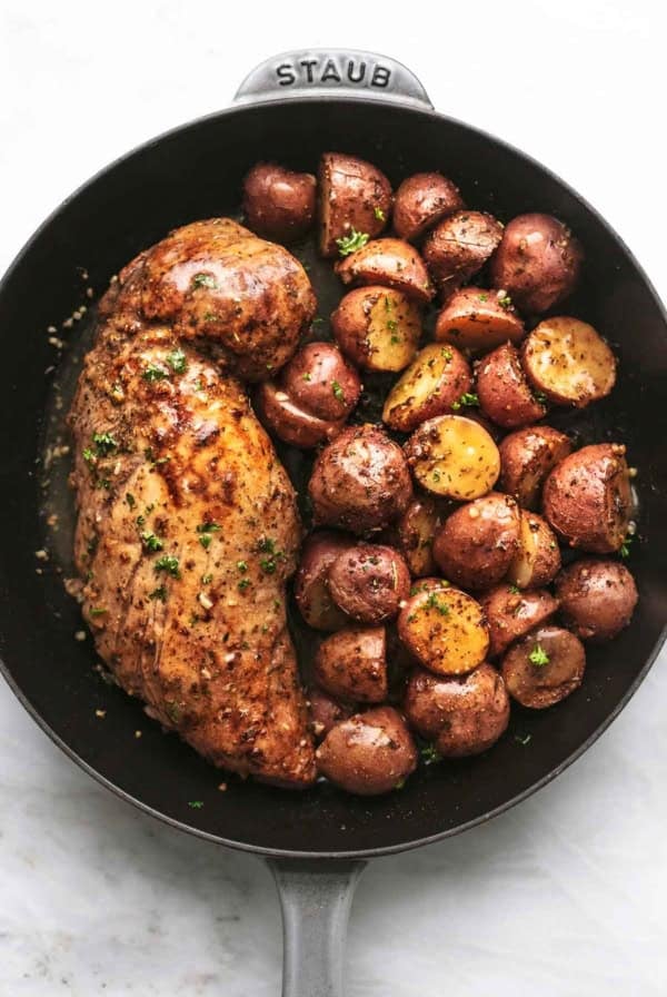 overhead view of pork tenderloin and baby potatoes cooked in a skillet