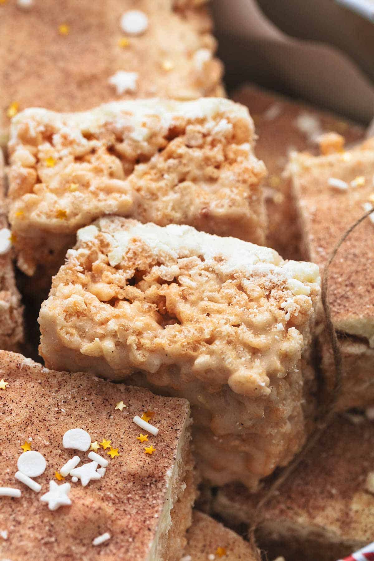 rice krispie bars topped with white chocolate and cinnamon-sugar with sprinkles and twine