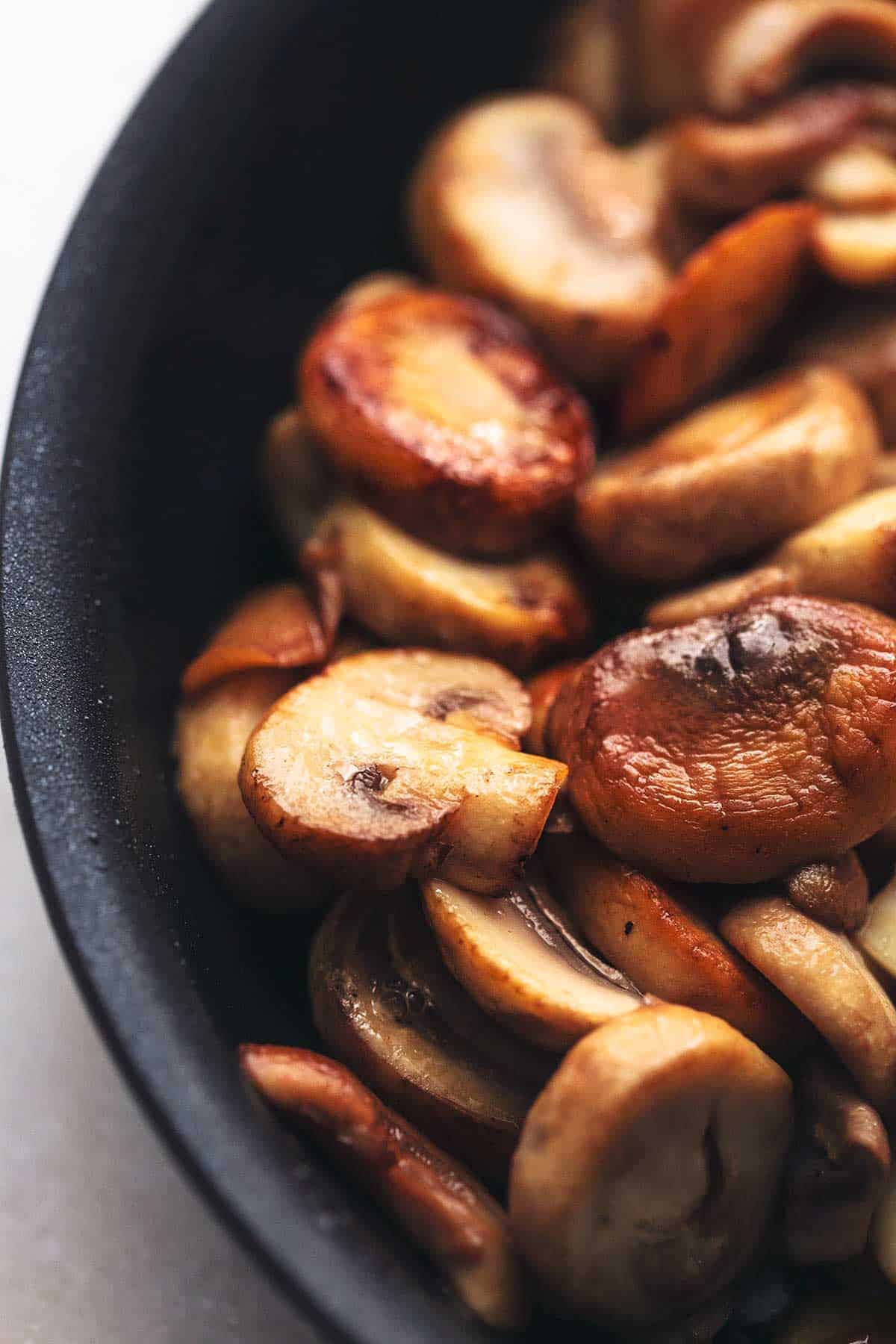 close up of mushrooms in a black skillet.