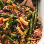up close green beans with crispy bacon and onions with wooden serving spoon