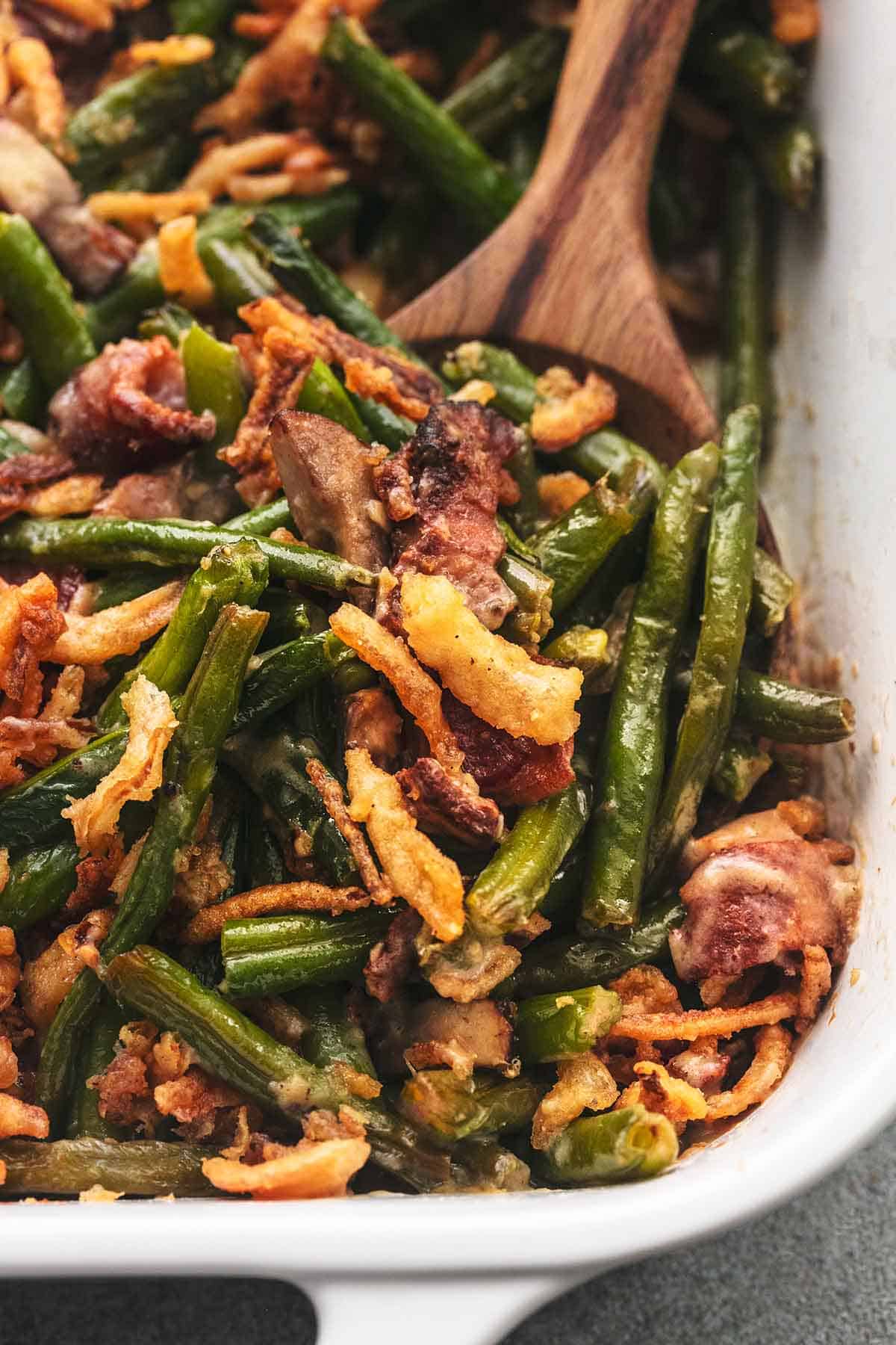 up close green beans with crispy bacon and onions with wooden serving spoon