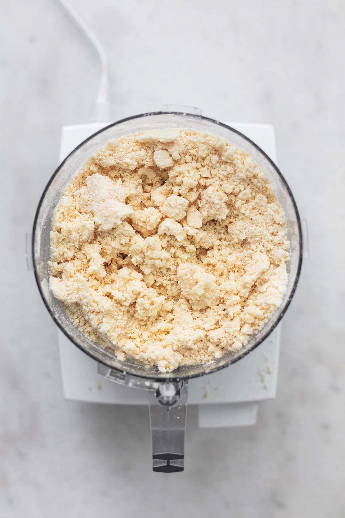 top view of pie dough mixture in a food processor.