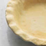 half of an unbaked pie crust with fluted edges