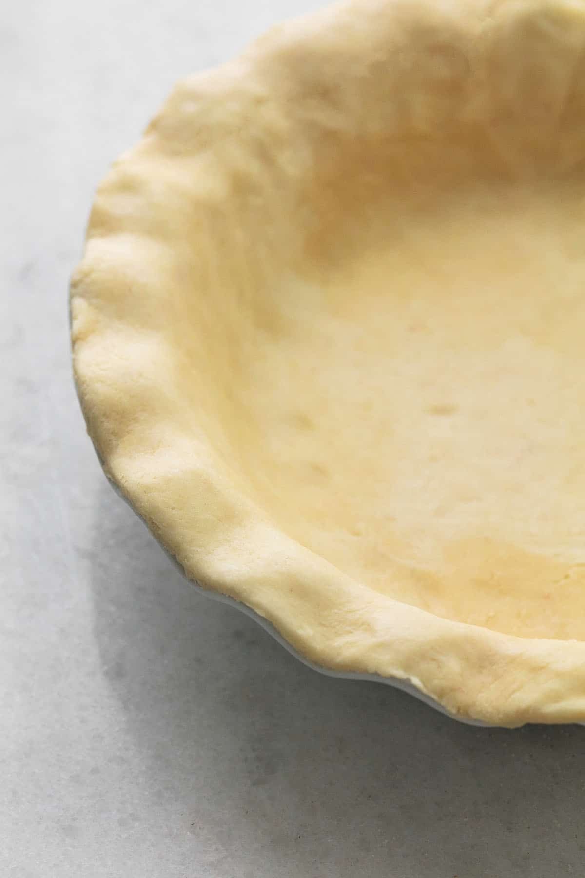 close up of unbaked pie crust in a pan.