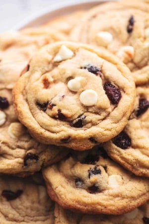 up close pile of cookies with white chocolate chips and cranberry pieces