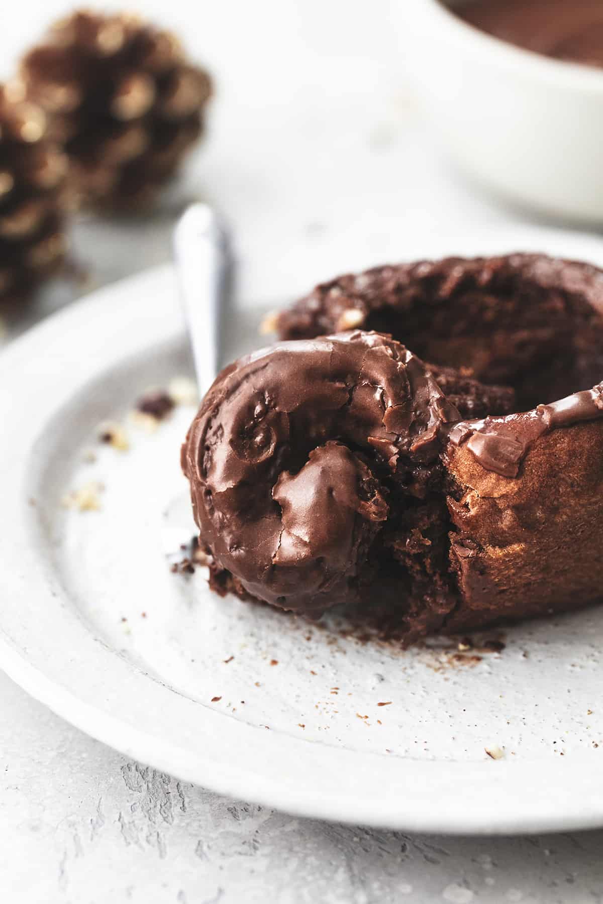 close up of a chocolate cinnamon roll with hazelnut icing with the center pulled out and sitting on a fork.