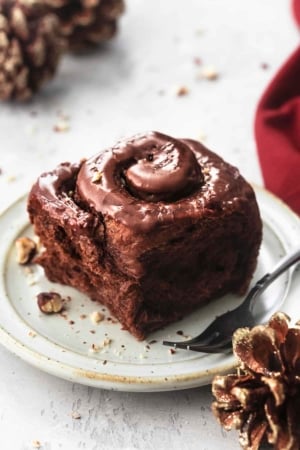 chocolate cinnamon roll on white plate with black fork
